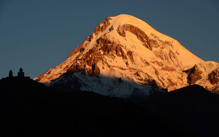 Sunrise at the foot of Mt. Kazbek  and Tsminda Sameba Monastery