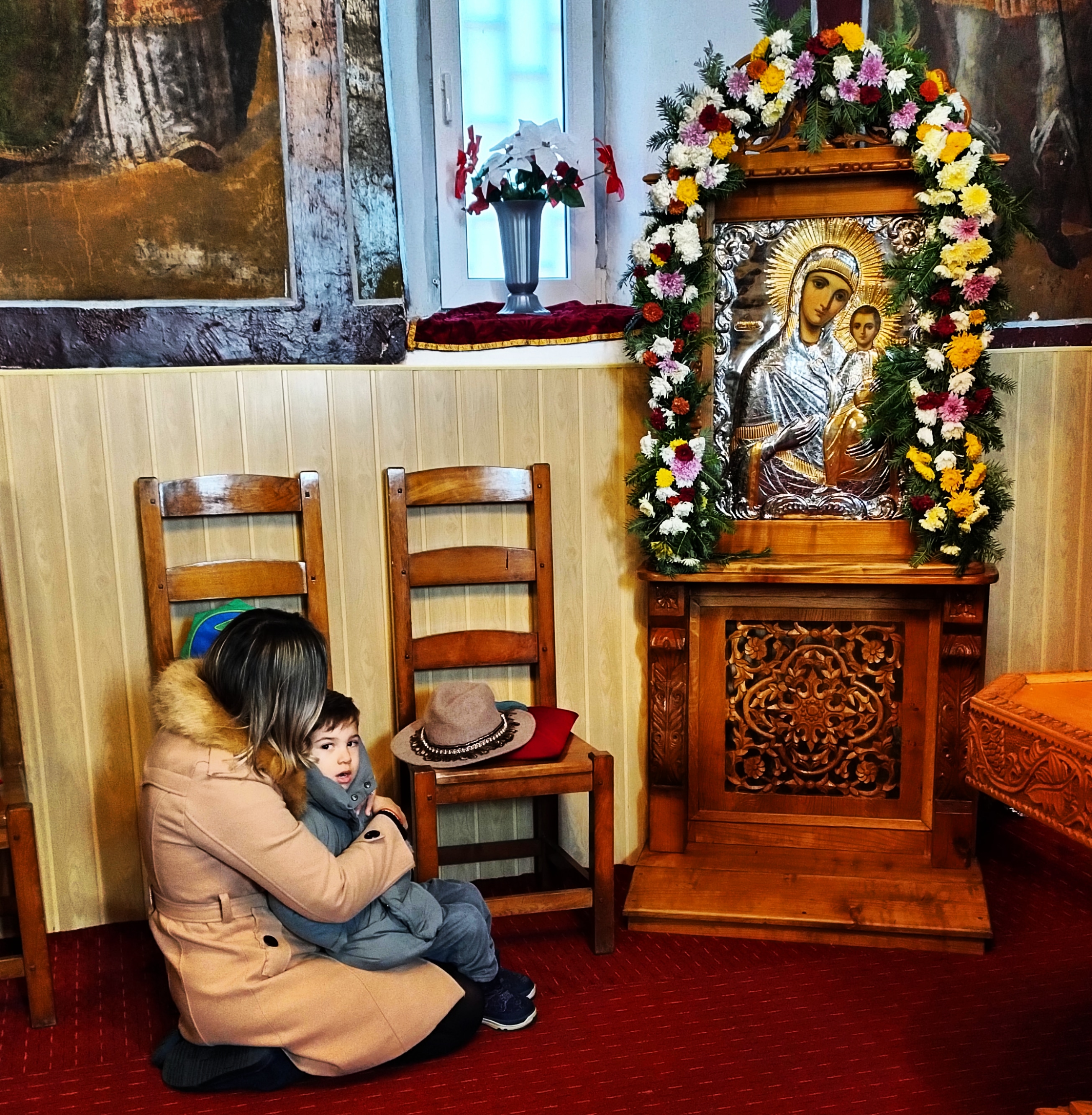 A mother and her son in front of the Mother of God and her Son 