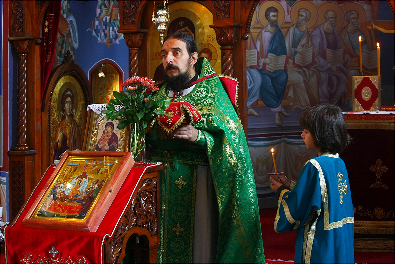 Father and son at the Holy Liturgy in Serbian small town Razana